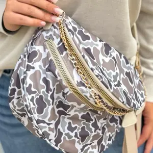 Crossbody bag with gold chain strap and zipper closure, suitable for daily use