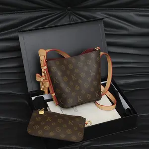 Bucket bag with gold-tone lock charm and detachable coin purse, classic printed crossbody bag for women, featuring red stitching, plush lining, adjustable shoulder strap, and top handle; a versatile bag perfect for commuting. fashionable