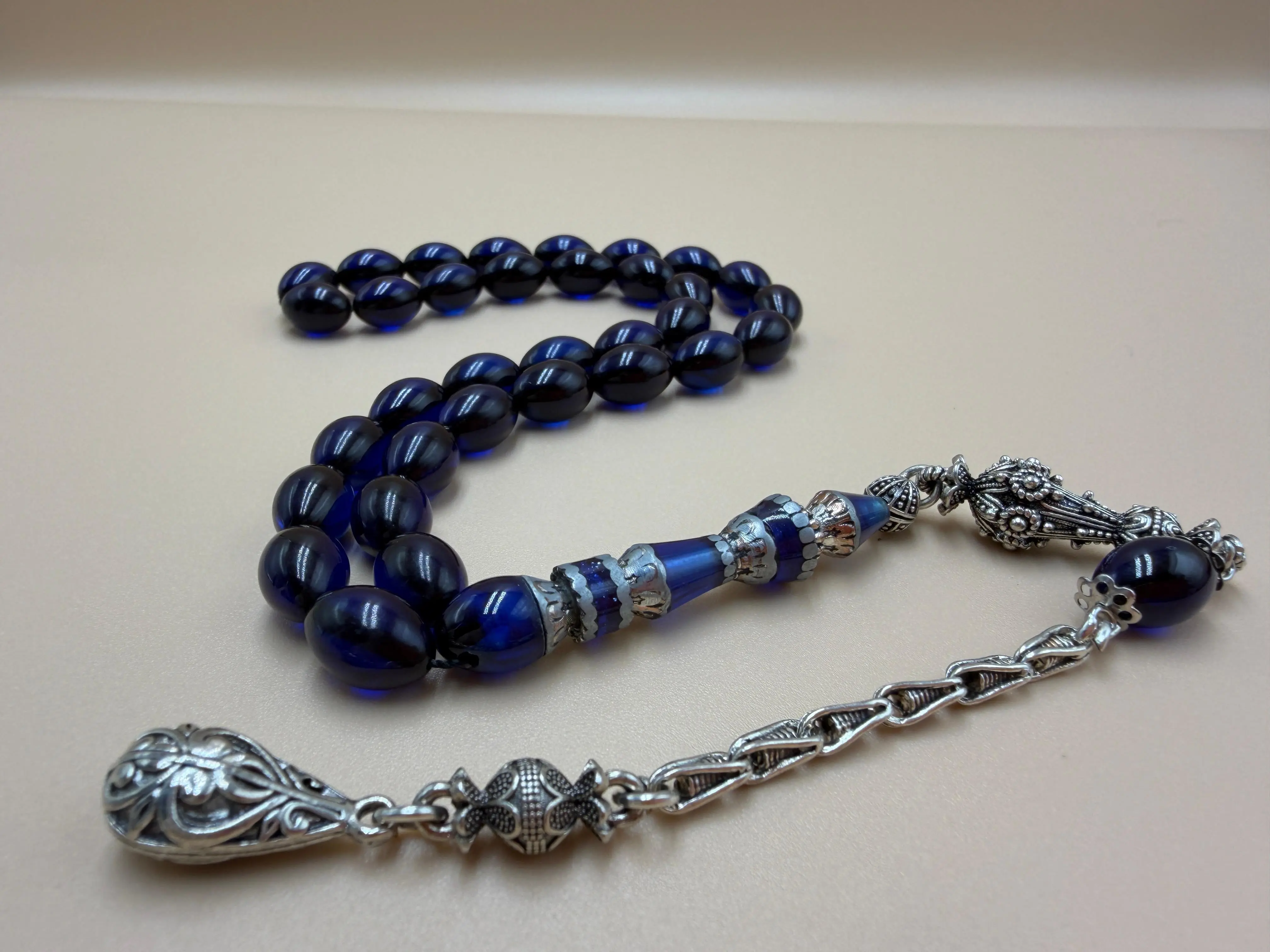مسباح سندلوس أزرق، مأذنة مشغولة مميّزة. Blue Sandalwood Misbah with a Distinctive Handcrafted Minaret-Style Finial.