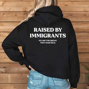 [Made in USA] Raised By Immigrants Hoodie Unisex Back Print, Immigrant Family Pride Quote Pullover Hoodie, American Dream Message Design, Cultural Identity Oversized Hoodie, Meaningful Empowerment Gift for Men Women
