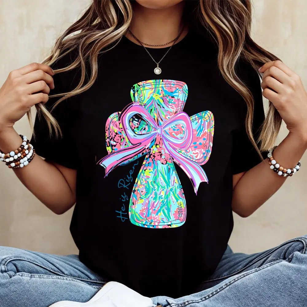 Cotton casual round-neck short-sleeve summer T-shirt with vibrant cross and bow design "He Is Risen" printed graphic tee machine washable not dry cleanable made in USA